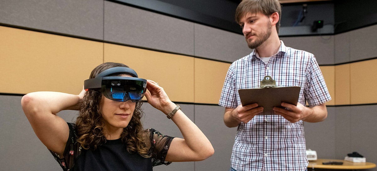 A graduate student works with lab manager through the augmented reality experiment during a testing phase.