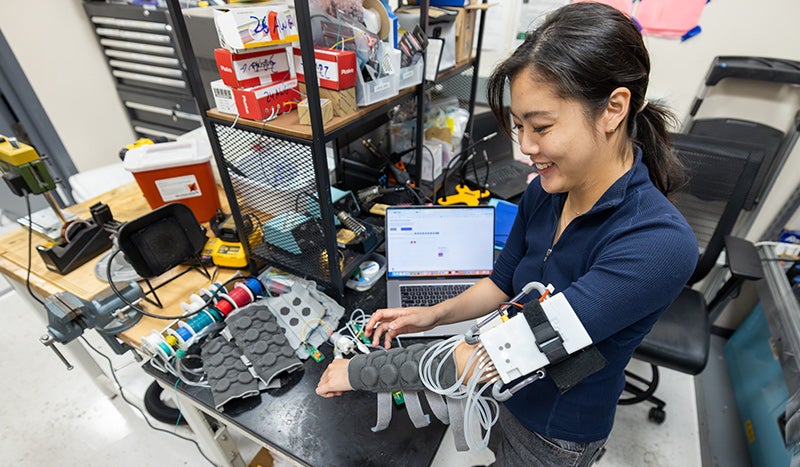 Yannie Tan, ʼ24, works on a haptic sleeve prototype at the Charm Lab.