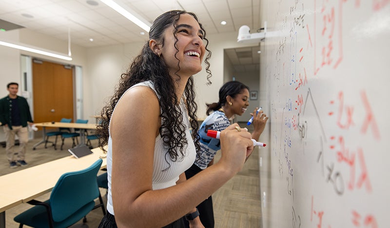 Undergraduate students working together to solve a math problem. 